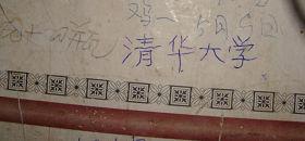 柳志梅在自家破舊的瓦窯墻上，寫下“清華大學”四個字