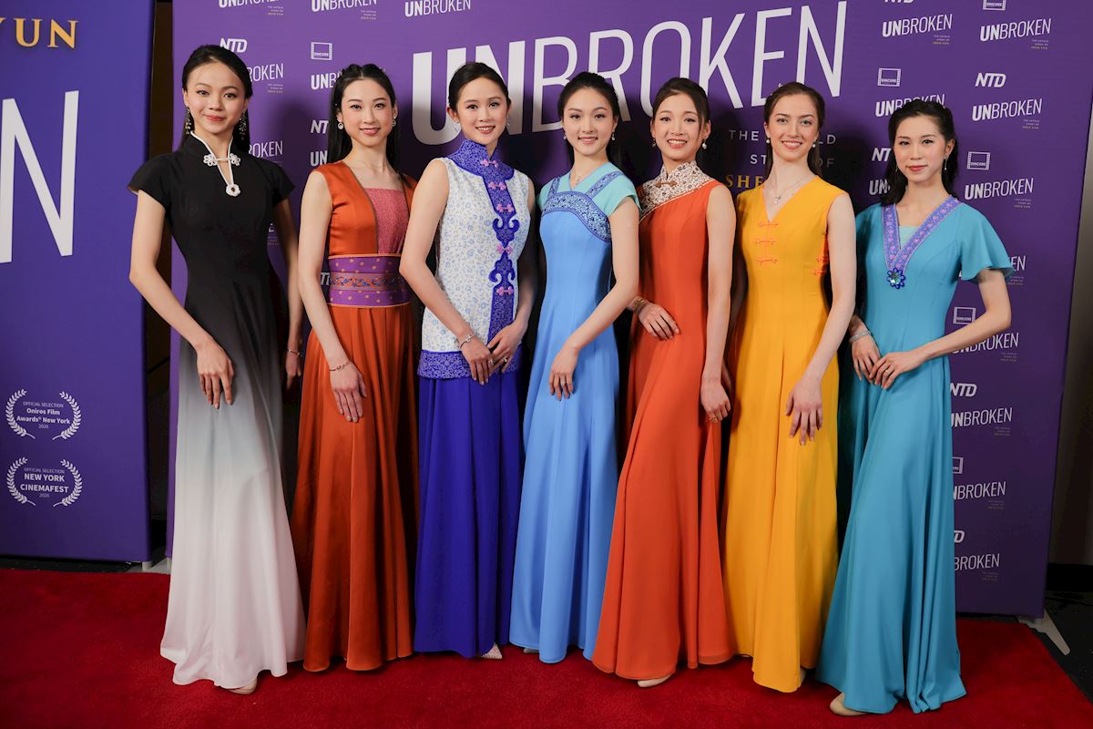 三月二十四日晚，神韵纪录片《坚不可摧》首映式在纽约林肯广场AMC影院举行。七位神韵艺术家身着由神韵艺术总监D.F.先生亲自设计、取材于中国不同朝代风格的礼服，莅临首映式前的隆重红毯欢迎仪式。（神韵作品）